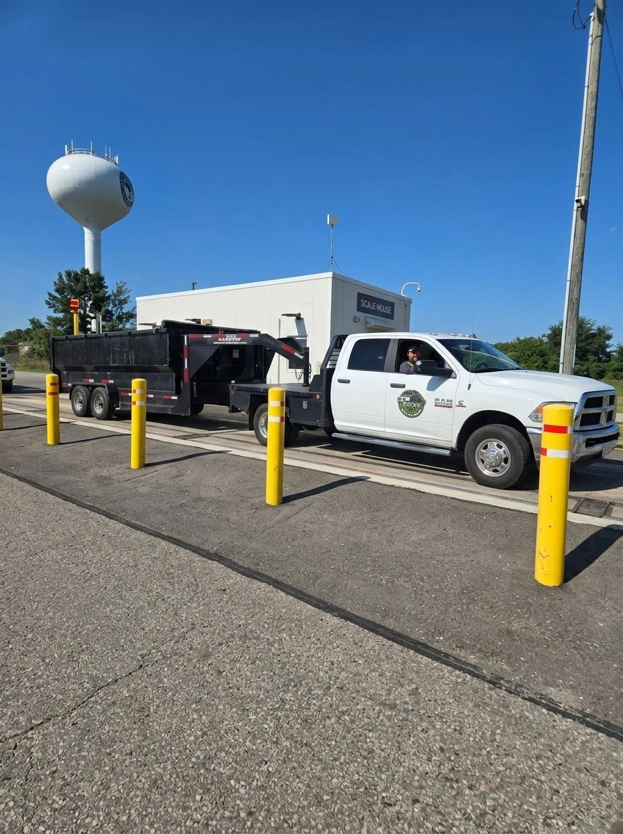 Elevex Outdoor Services white truck and dump trailer at a service facility